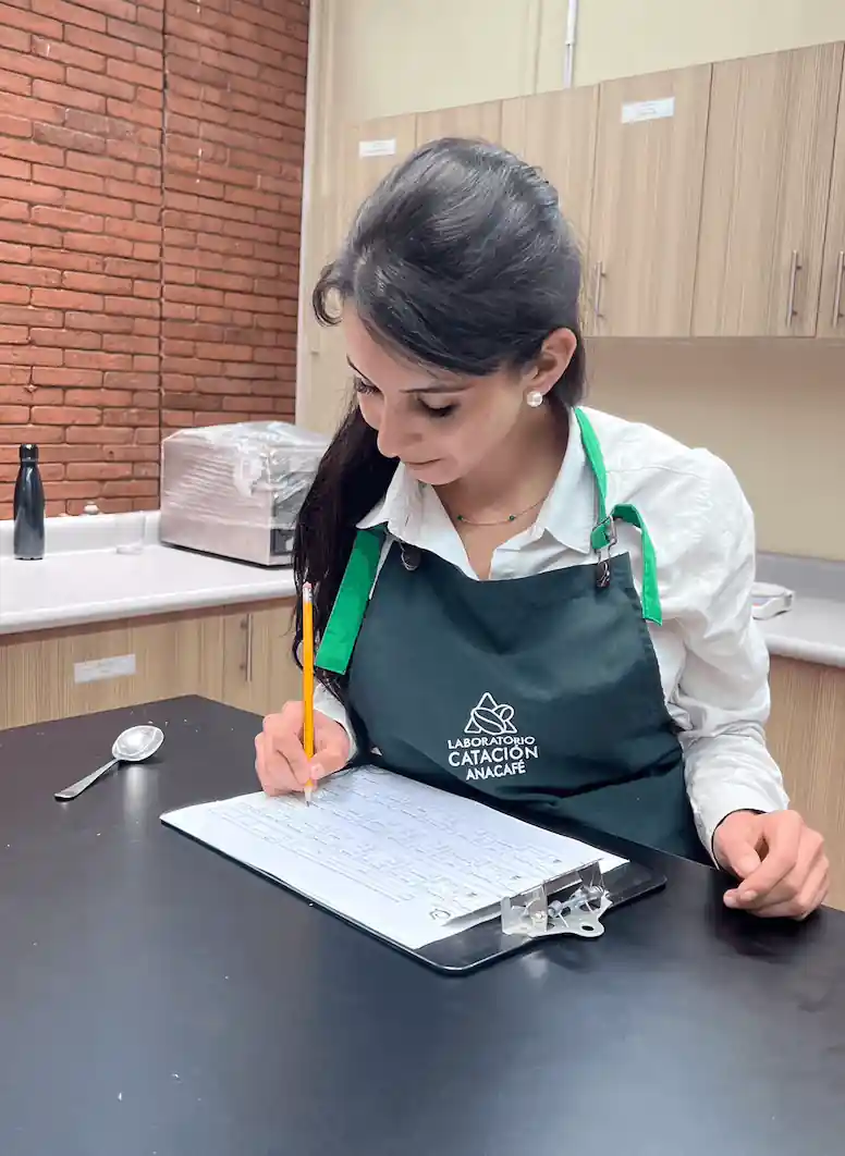 A Linda Morena cupper fills in a cupping sheet in a cupping lab.